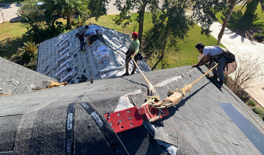 StormForce crew on top of a residential home working on a roof repair.