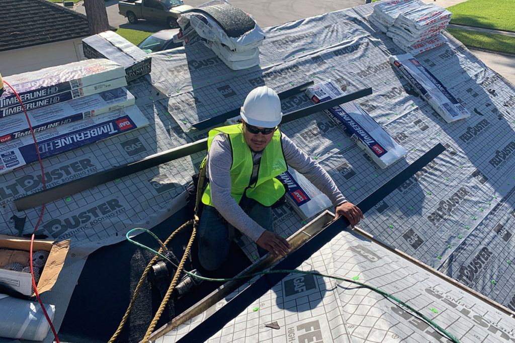 A StormForce Roofing crew member working on the roof of a home with GAF Timberline HD shingles.
