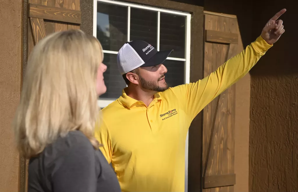 StormForce crew member pointing at something while talking with a customer.