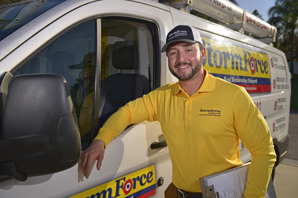 A StormForce team member standing next to a company vehicle.
