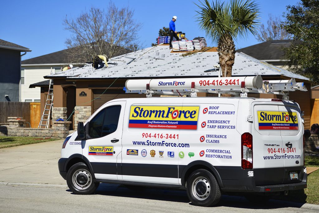 StormForce Roofing crew on the roof of a home installing new roofing materials.