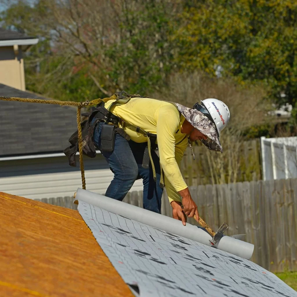 A StormForce crew member installing underlayment on a new roof.