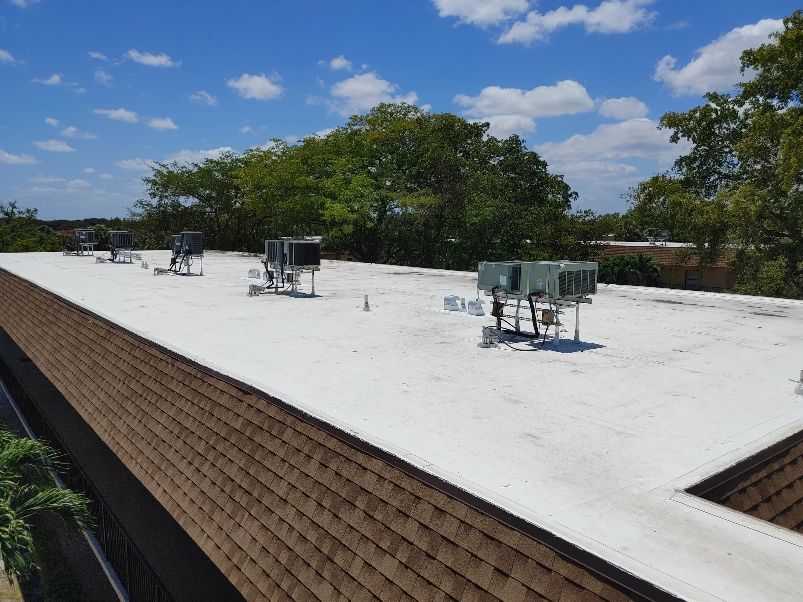 A completed flat roof with a reflective white coating, typically used for energy efficiency and extending the roof life on commercial buildings.