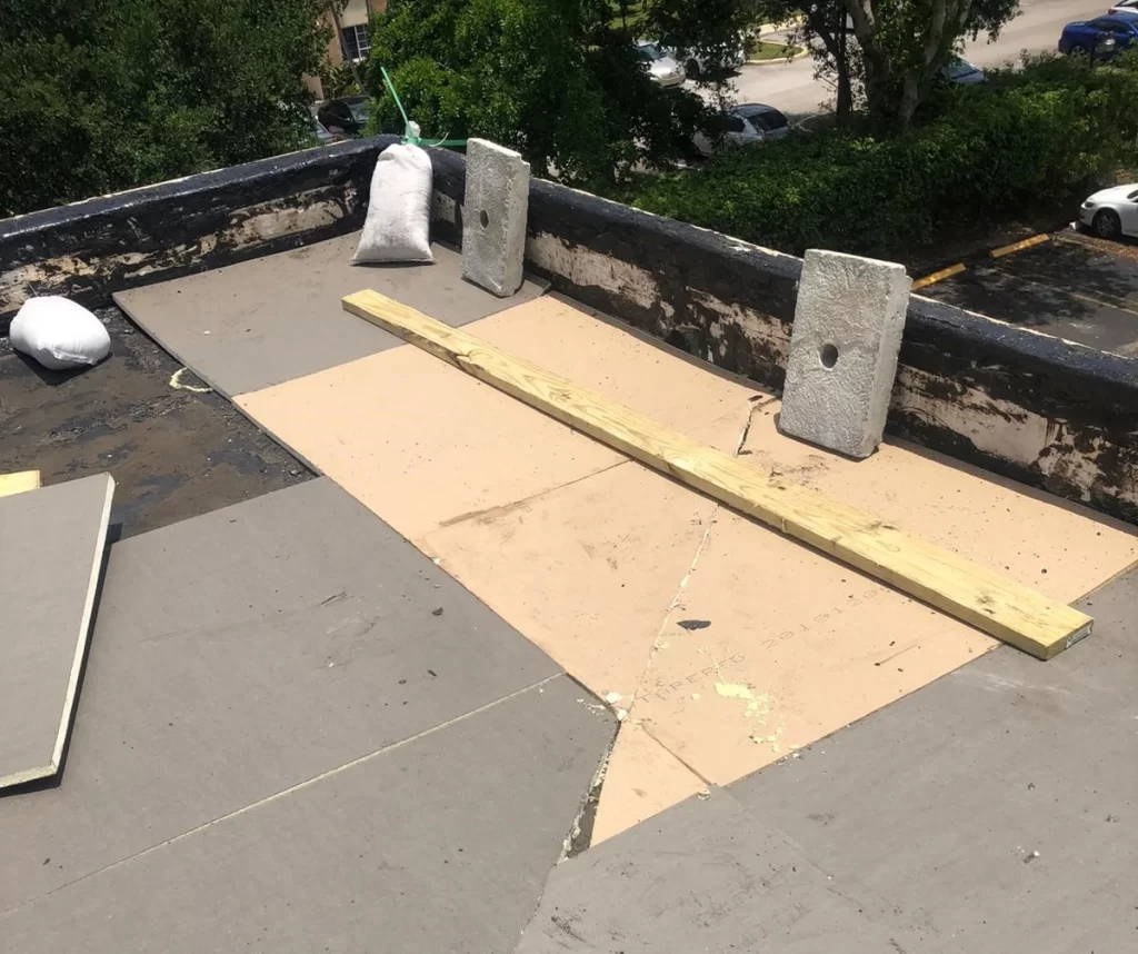 Close-up of insulation boards being laid on a flat roof for thermal efficiency, part of the industrial roofing process.
